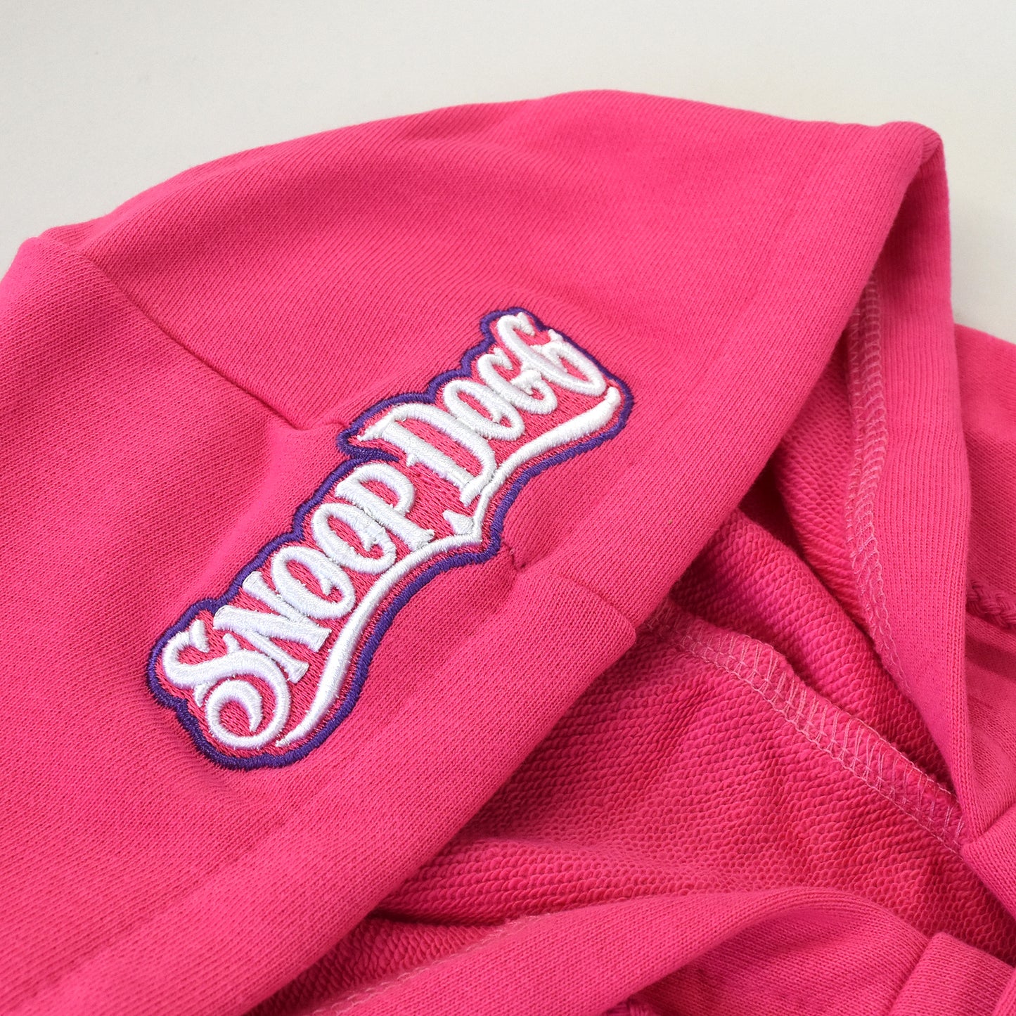 A close up detail image of the Snoop Dogg embroidered logo on the hood of the Boss Lady Deluxe Pet Hoodie.
