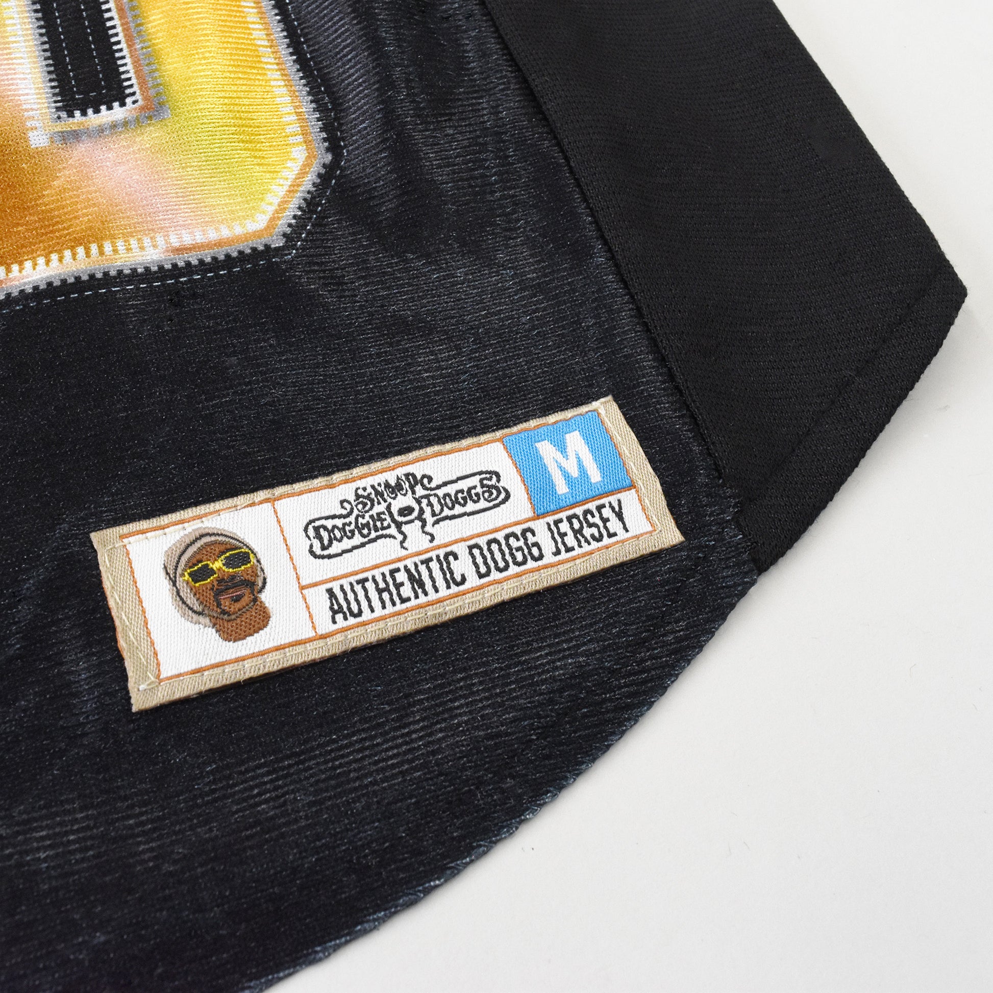 A close up detail image showing design sublimation, stretch fabric, and embroidered jersey tag of the Off The Chain Deluxe Pet Jersey.